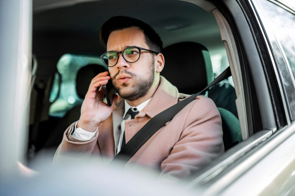 車で電話をしている男性