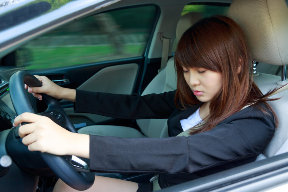 居眠り運転をしている女性